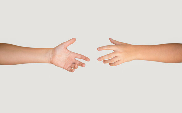 Help, helping, suport. Closeup two hands reaching to each other. Concept for salvation, rescue, friendship, guidance, help, helping. Man's hand holds a hand of the child. Child and woman hands