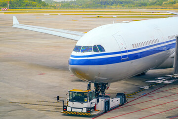 Airliner jet push back with a tug on the airport, cockpit view