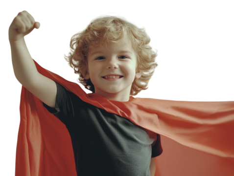 Boy wearing red superhero cape, raising arm, smiling joyfully, isolated on white background.  PNG transparent.