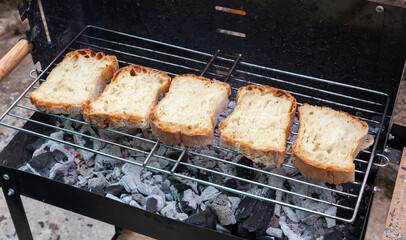 Slices of bread toasting on a barbecue grill