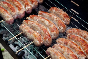 Juicy sausages grilling on a barbecue grill