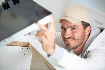 man is installing a furniture