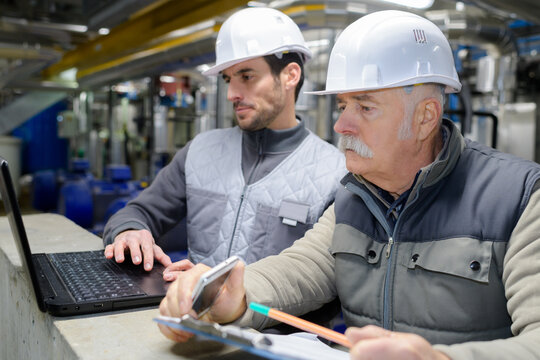 colleagues wearing hard hats checking document