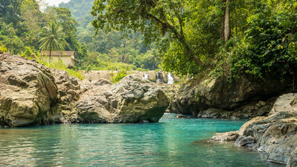 Naklejka premium Amazing view of river with clear blue water with rocks and tropical forest mountains in the interior of the Sumatran forest, Indonesia