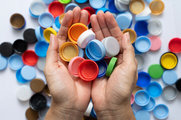 woman hand holding plastic bottles caps for recycling to conserve the environment, Recycling, reuse, garbage disposal, save the world concpet.