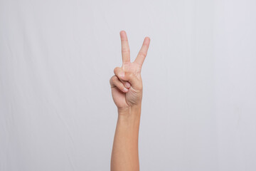 Peace symbol with hands. Hand showing two fingers, isolated on white background. People's hands are raised upwards to form a "Peace" gesture.