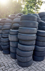 Obraz premium Pile of old tires waiting to be recycled in a junkyard