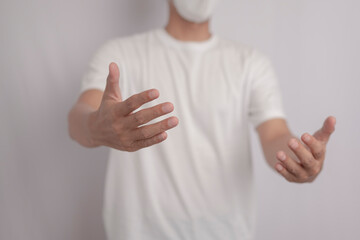 Portrait of Asian man wearing white shirt with open arms, greeting, giving hug standing on white background.