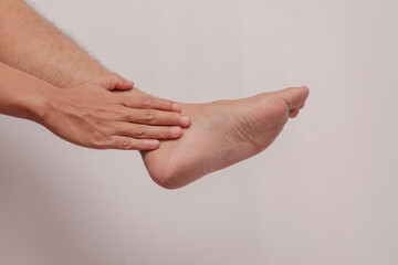 Fototapeta premium A man's leg suffers from gout. The feet experience inflammation of the feet which are held by the hands. health concept on foot inflammation.