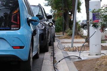 Charging electric cars. Electric cars charging from a column.Charging electric cars at a street charging station. Italy