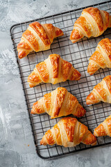 Freshly baked golden croissants on cooling rack. Generative AI image