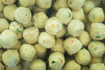 A collection of meatballs with fish, shrimp and meat flavors in a refrigerator in a supermarket that are sold to consumers.