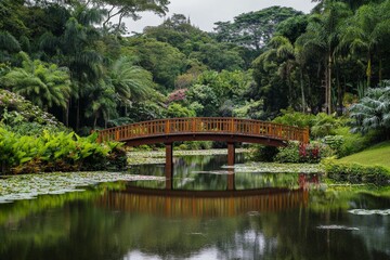 A stunning garden scene featuring a lush variety of plants and trees, with a wooden bridge crossing over a tranquil pond adorned with lotus flowers and lily pads.