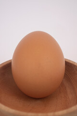 Brown eggs on wooden plate isolated on white background. Eggs are a common ingredient in cooking. Egg protein is a protein that can be absorbed efficiently. Food concept. Modern chicken farming.