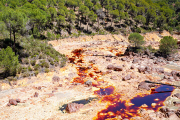 Rio Tinto river and iron mines. Red tinted river by copper, iron on the ground. Water used in life...