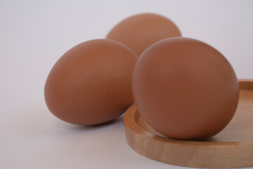 brown eggs on wooden plate isolated on white background. Eggs are a common ingredient in cooking. Egg protein is a protein that can be absorbed efficiently. Food concept. Modern chicken farming.