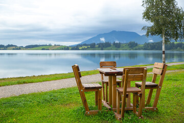 a set of outdoor desk stands beside a peaceful lake