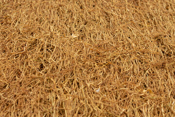 The process of drying chopped tobacco leaves. A close-up of a piece of dried tobacco leaf. The main ingredient for cigarette products.