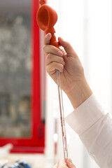 Scientist using red pipette pump in laboratory setting