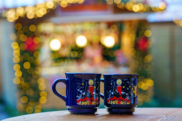 Two glasses mugs with mulled wine or punch on Christmas Market in Germany. Traditional alcoholic drinks on German xmas funfair