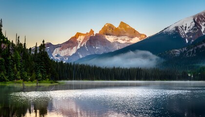 sunrise in the mountains with snow capped peaks.