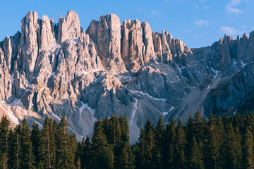 Picturesque peaks of Dolomites mountains surrounded by coniferous forest. Scenic place and famous touristic destination at day time. Primeval breathtaking nature landscape