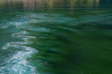 Water vortex of a ship's propeller in green water