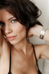 Portrait of a young brunette woman with blue eyes. A young woman with a pleasant face looks into the frame.