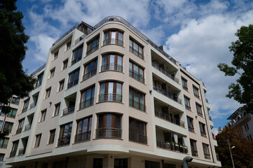 Modern apartment building showcasing curved architecture in an urban neighborhood under a clear...