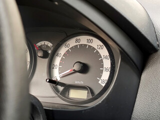Speedometer and fuel gauge in an older used car interior, detail closeup, nobody. Stationary...
