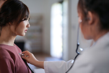 Asian psychologist women using stethoscope to check up patient and giving counseling about medicine...