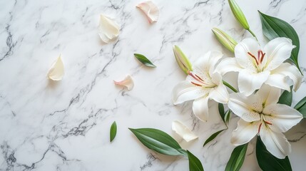 White lilies placed on a marble countertop, next to scattered petals and leaves.