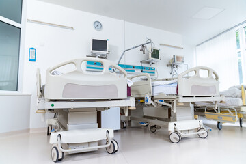A hospital room with two beds and a clock on the wall. The room is clean and well-lit, giving off a sense of calm and order