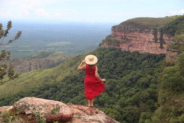 Naklejka premium mulher de vestido vermelho e chapéu no mirante Alto do Céu, na Chapada dos Guimarães, Mato Grosso 