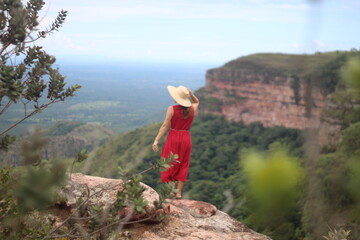 mulher de vestido vermelho e chapéu no mirante Alto do Céu, na Chapada dos Guimarães, Mato Grosso 