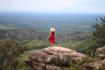 Fototapeta premium mulher de vestido vermelho e chapéu no mirante Alto do Céu, na Chapada dos Guimarães, Mato Grosso 