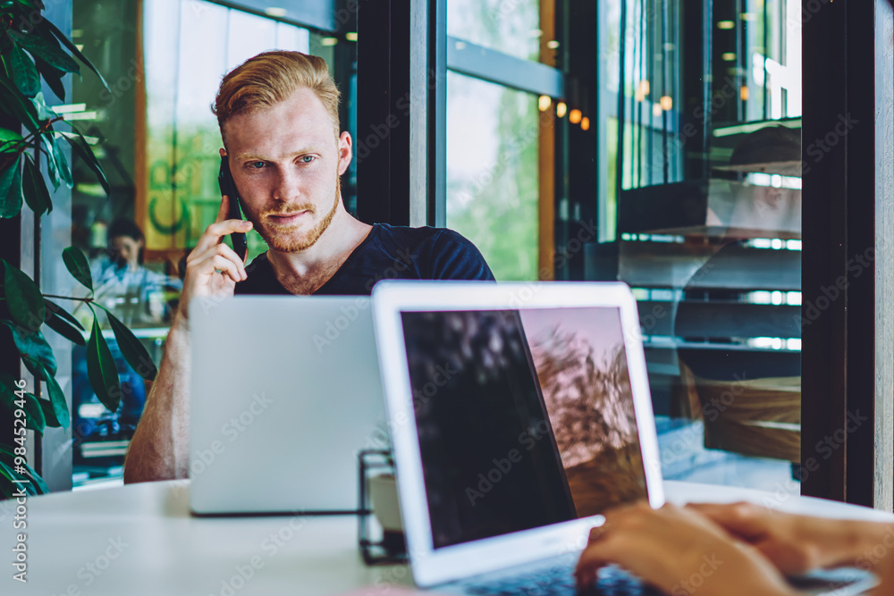 Aufkleber caucasian hipster guy calling to operator for discussing details about internet connection on laptop
