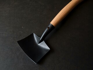 Elegant black metal shovel with a wooden handle.