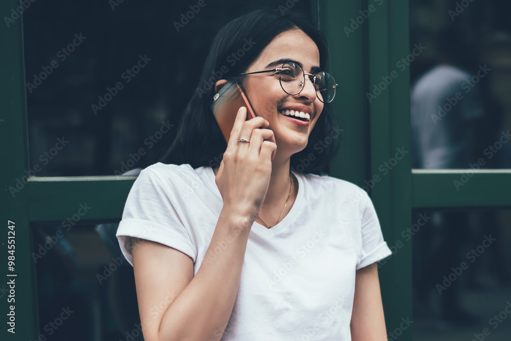 Poster excited hipster programmer in copy space t-shirt laughing during friendly smartphone conversation en