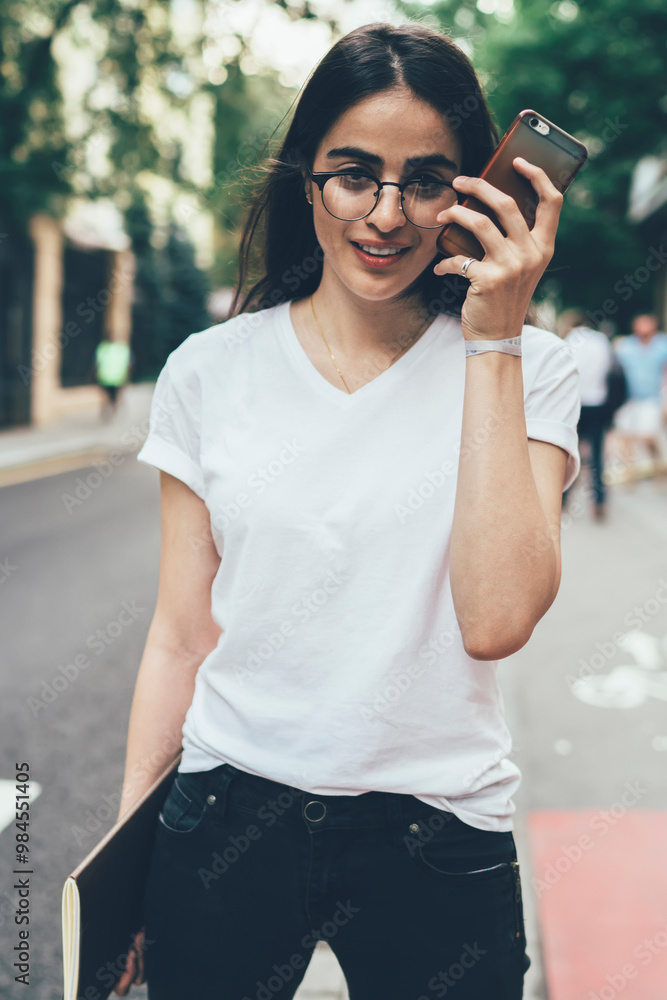 Poster attractive female student with knowledge sketchbook for design in hand looking at camera while liste