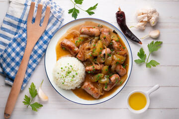Sausages cooked with onion and pear. Top view table with 
 decoration.
