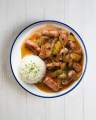Sausages cooked with onion and pear. Top view table with 
 decoration.