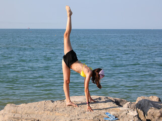 girls balancing on rocks with one leg very high and the other forming a 180 degree angle