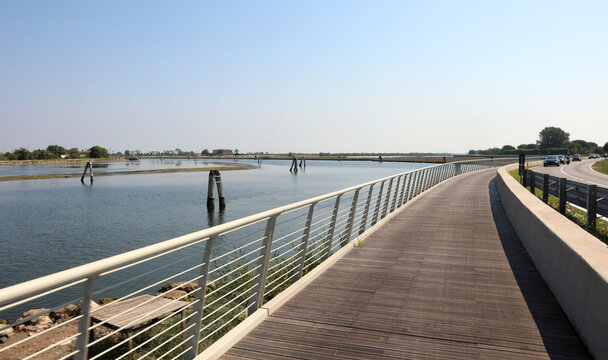 modern bridge on cycle path made of wood and steel railings that runs along the Venetian lagoon at Treporti near Jesolo and the island of Venice