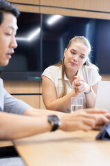 Fototapeta premium At office, multiracial colleagues collaborating in modern office with laptop