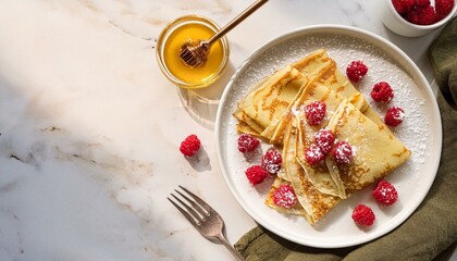 Creative food template. Plate of Cr&ecirc;pe Cr&ecirc;pes crepe waffle pastry dessert with raspberry fruit, maple honey and powder sugar, morning sunlight shining on marble table. copy text space, top flat lay