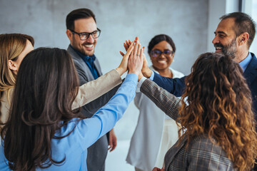 Team Celebrating Success with Group High Five in Office