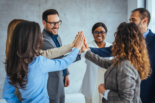 Diverse Team Celebrating Success With High Five in Office