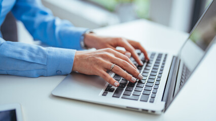 Professional Woman Typing on Laptop in Office Setting