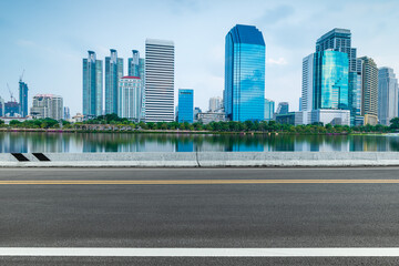 Asphalt road and city skyline with modern buildings scenery. Side view of asphalt road.